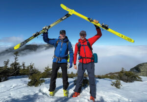 Two men holding skis